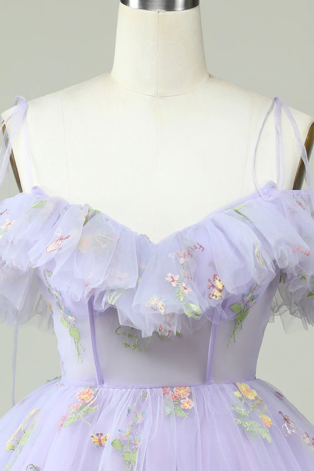 Close-up of the ruffled off-shoulder neckline and corset detail on a lavender dress.