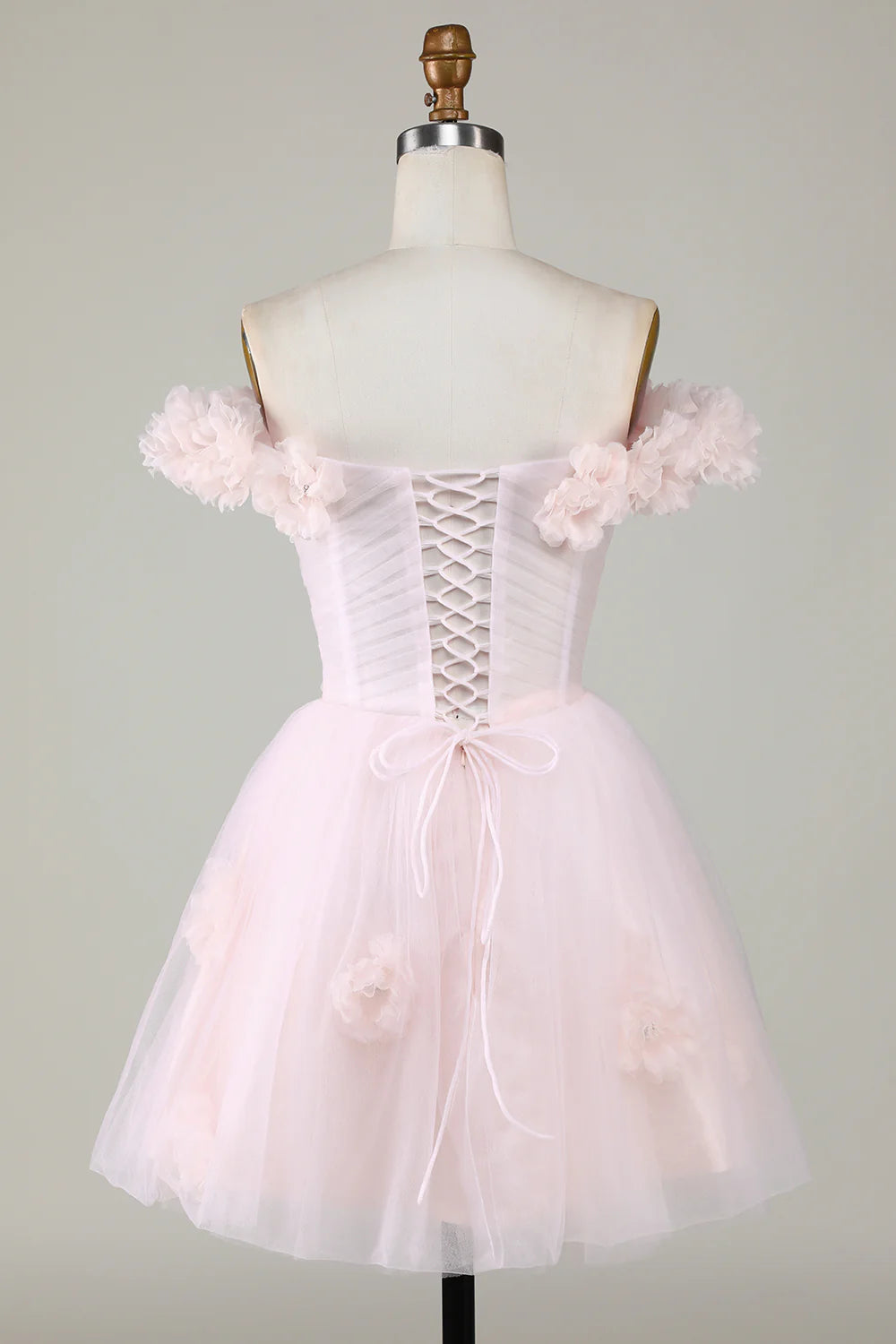 Side view of the pink A-line off-shoulder dress, showcasing floral embellishments.