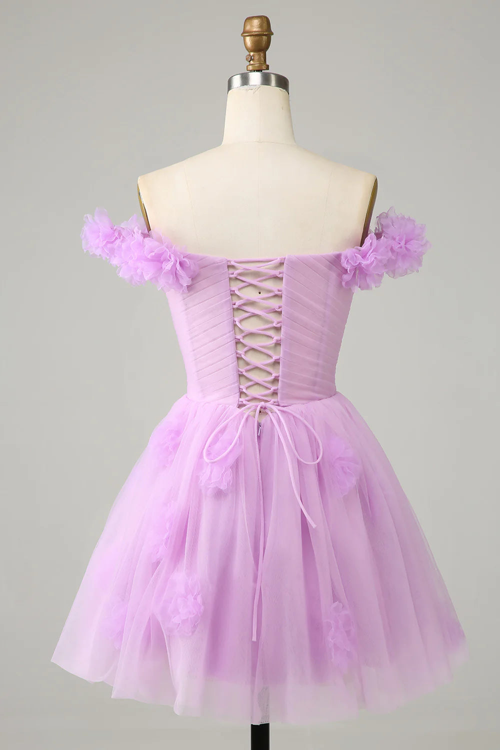Model wearing the pink A-line off-shoulder dress, highlighting its knee-length.