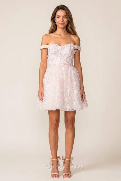 Model wearing a blush pink off-shoulder mini homecoming dress with 3D floral appliques and sequins.