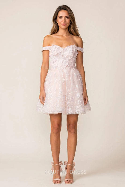 Model wearing a blush pink off-shoulder mini homecoming dress with 3D floral appliques and sequins.