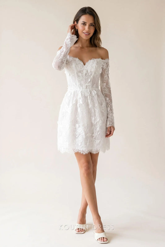 Model wearing a white lace off-shoulder mini homecoming dress with long sheer sleeves and floral appliques.