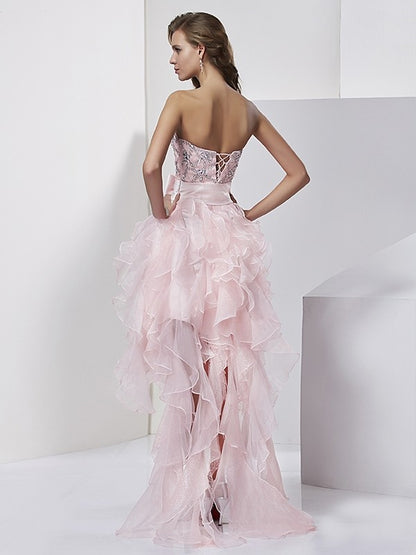 Back view of a model in a Koutun A-Line Princess strapless high-low organza homecoming dress.