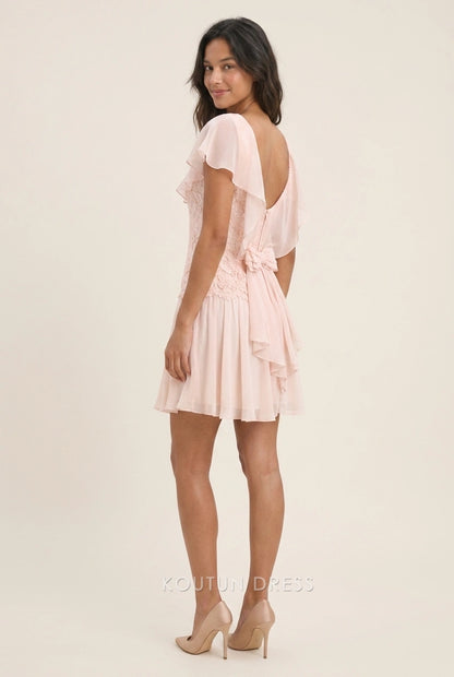 Back view of blush pink homecoming dress showing ruffled flutter sleeves and bow detail.