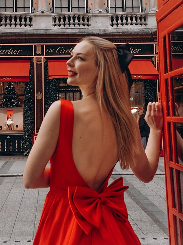 Back view of a tea-length satin dress with a delicate bowknot detail.