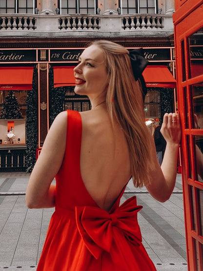 Back view of a tea-length satin dress with a delicate bowknot detail.
