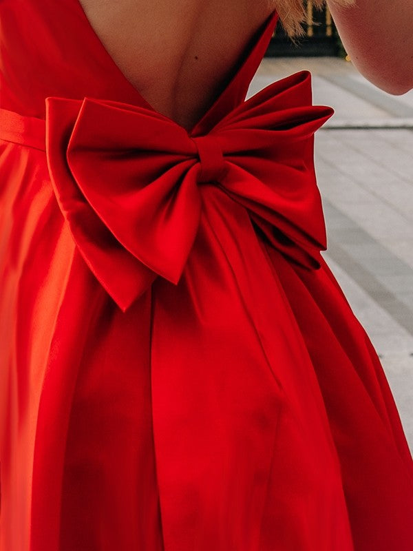 Close-up of the square neckline and bowknot on a satin homecoming dress.