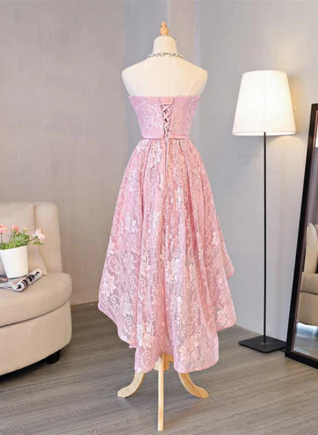 Back view of a model in a pink lace high-low prom dress.