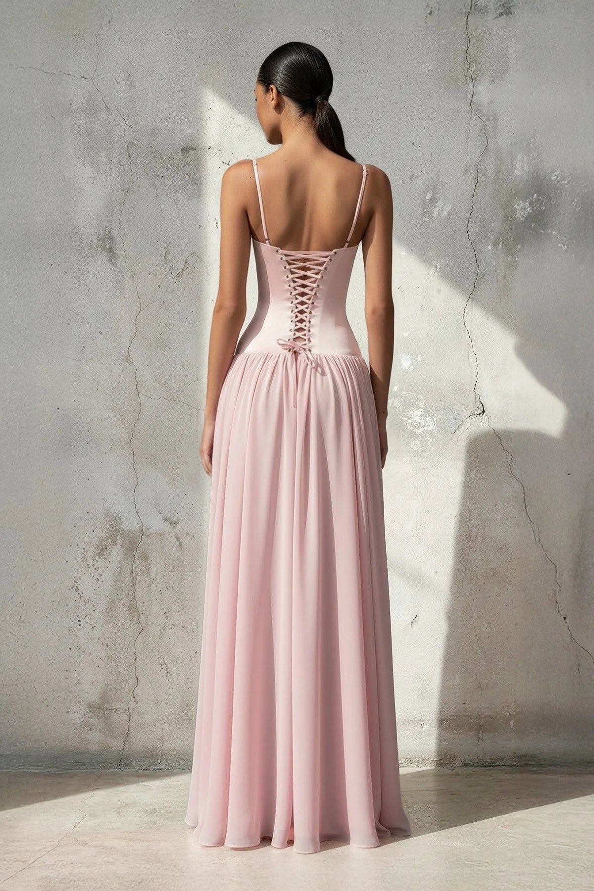 Back view of chiffon formal gown showing lace-up corset detail.