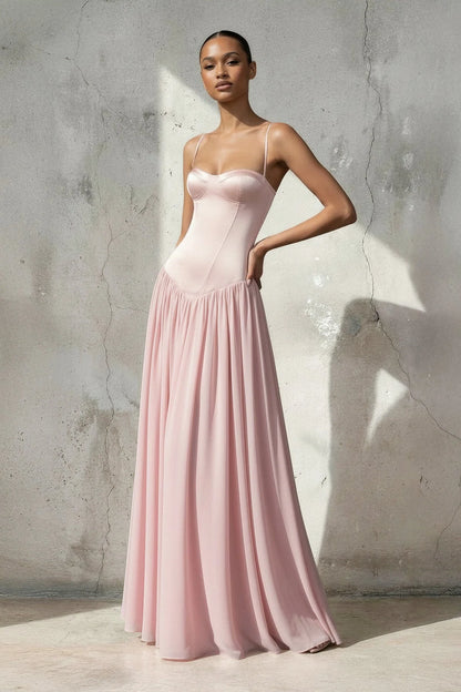 Full view of a woman in a spaghetti strap chiffon prom dress.
