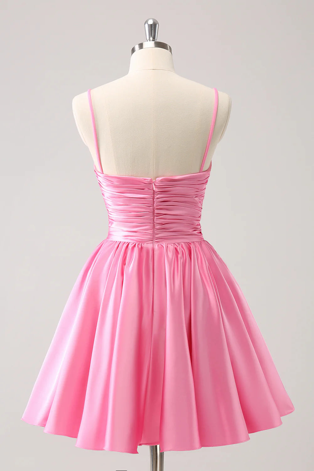 Pink A-line homecoming dress with pleated skirt and spaghetti straps.