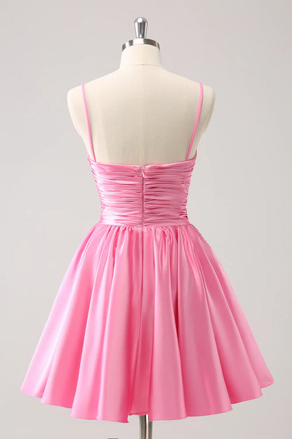 Pink A-line homecoming dress with pleated skirt and spaghetti straps.