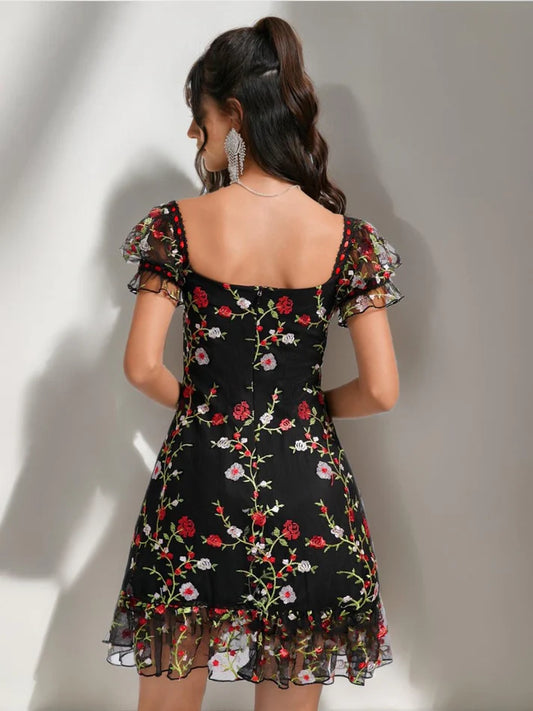 Back view of the A-line short homecoming dress, showcasing ruffle and embroidery details.