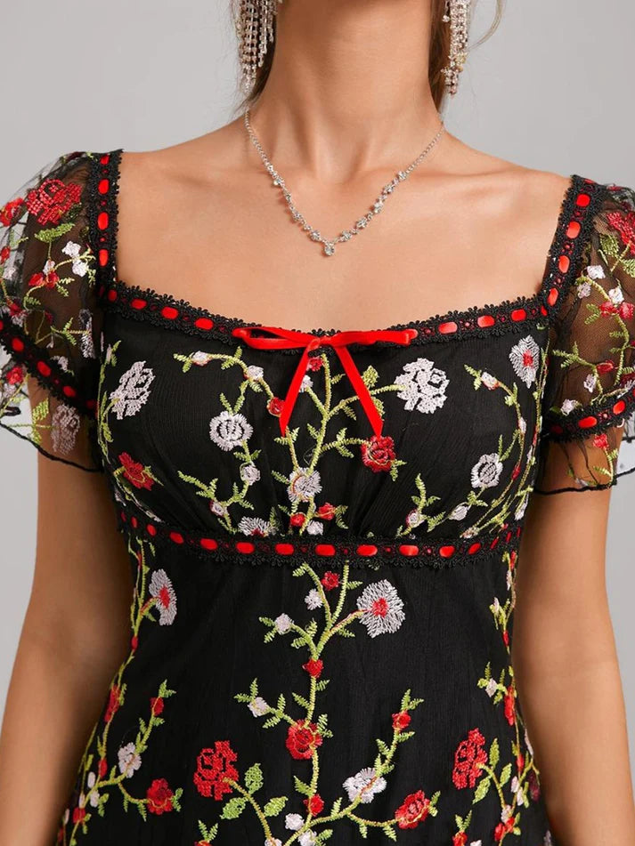 Close-up of the square neckline and puff sleeves on the embroidered homecoming dress.