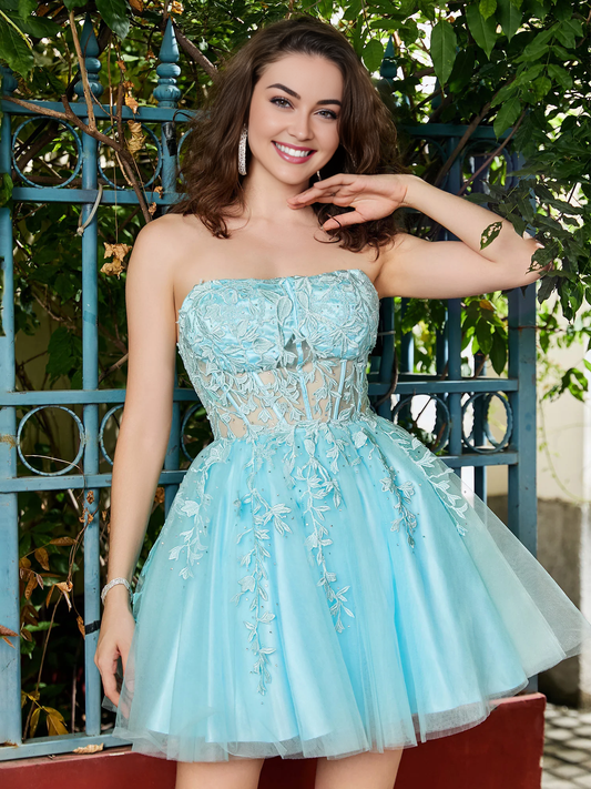 Model wearing an elegant A-line strapless short homecoming dress with sheer lace and tulle.