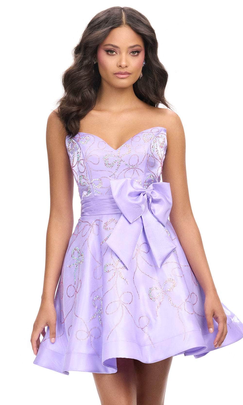 Woman wearing a lavender strapless sweetheart A-line mini homecoming dress with rhinestone bow and satin waist bow.