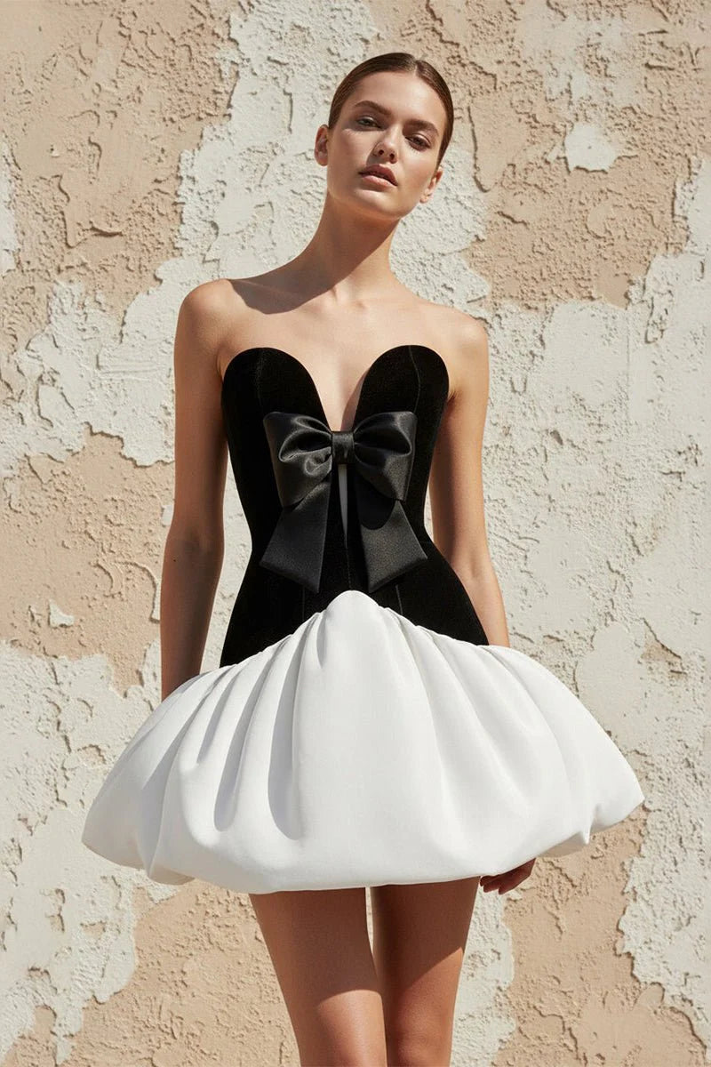 Model wearing Koutun strapless velvet mini homecoming dress with bubble hem, front view.