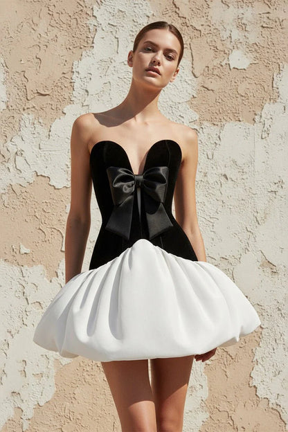 Model wearing Koutun strapless velvet mini homecoming dress with bubble hem, front view.