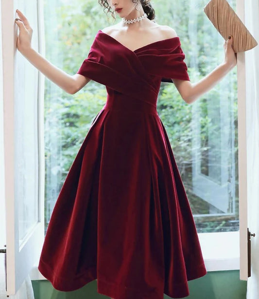 Model wearing a wine red velvet A-line tea length strapless dress.