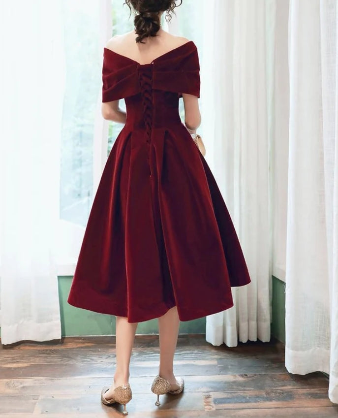 Close-up of the wine red velvet fabric and strapless neckline of the dress.