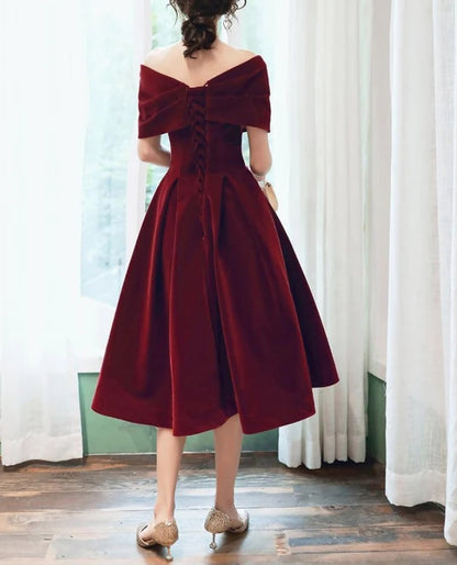 Close-up of the wine red velvet fabric and strapless neckline of the dress.