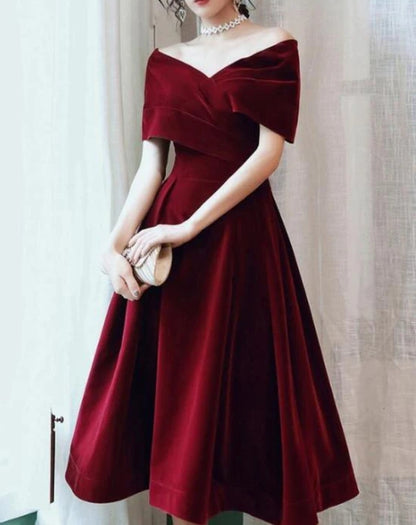 Side profile of a model in the wine red velvet strapless dress.