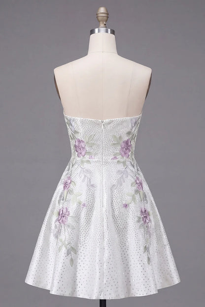 White strapless dress with sweetheart neckline and floral details.