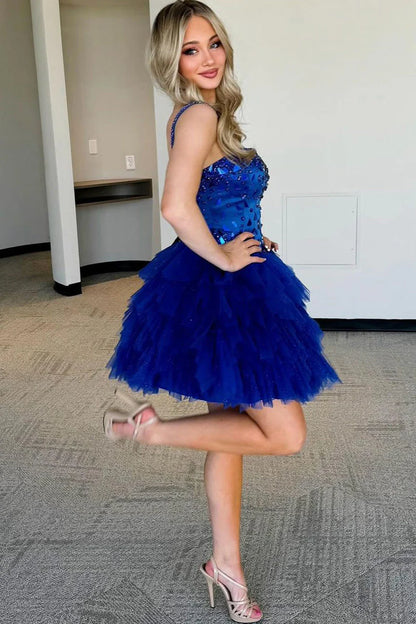 Close-up of the beaded bodice and ruffled tulle on a royal blue A-line dress.
