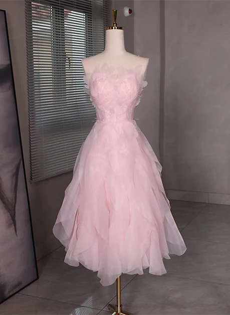 Model wearing a pink tulle short dress with beading and a low back.