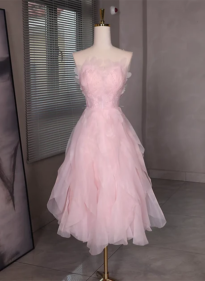 Model wearing a pink tulle short dress with beading and a low back.