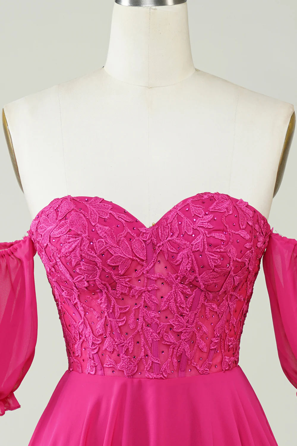 Close-up of the lace and chiffon fabric on the fuchsia A-line dress.