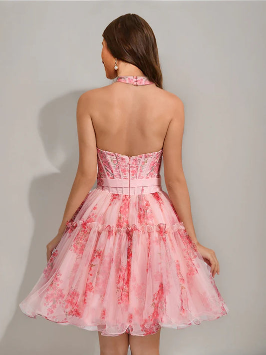 Back view of a model in a short floral A-line dress with ruffles.