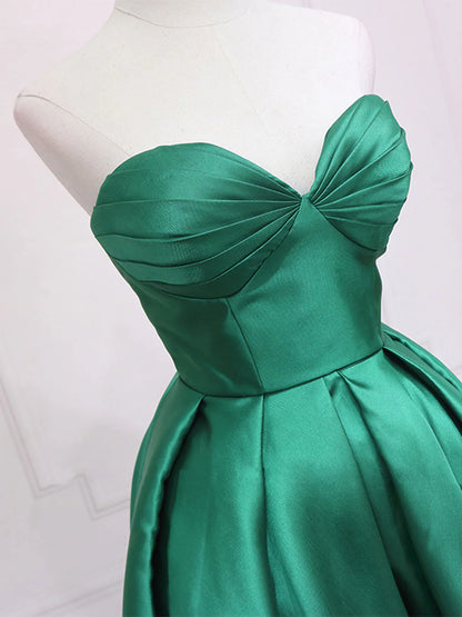 Side view of a flowing green high-low dress with sweetheart neckline.