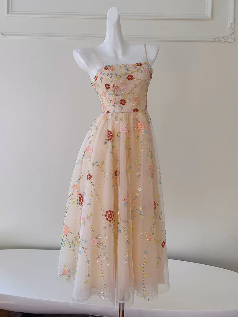 Front view of an A-Line champagne pink tea-length prom dress with a sequin bodice and flowing tulle skirt.