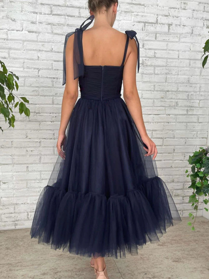 Model wearing an elegant dark blue short homecoming dress, showcasing the back detail.