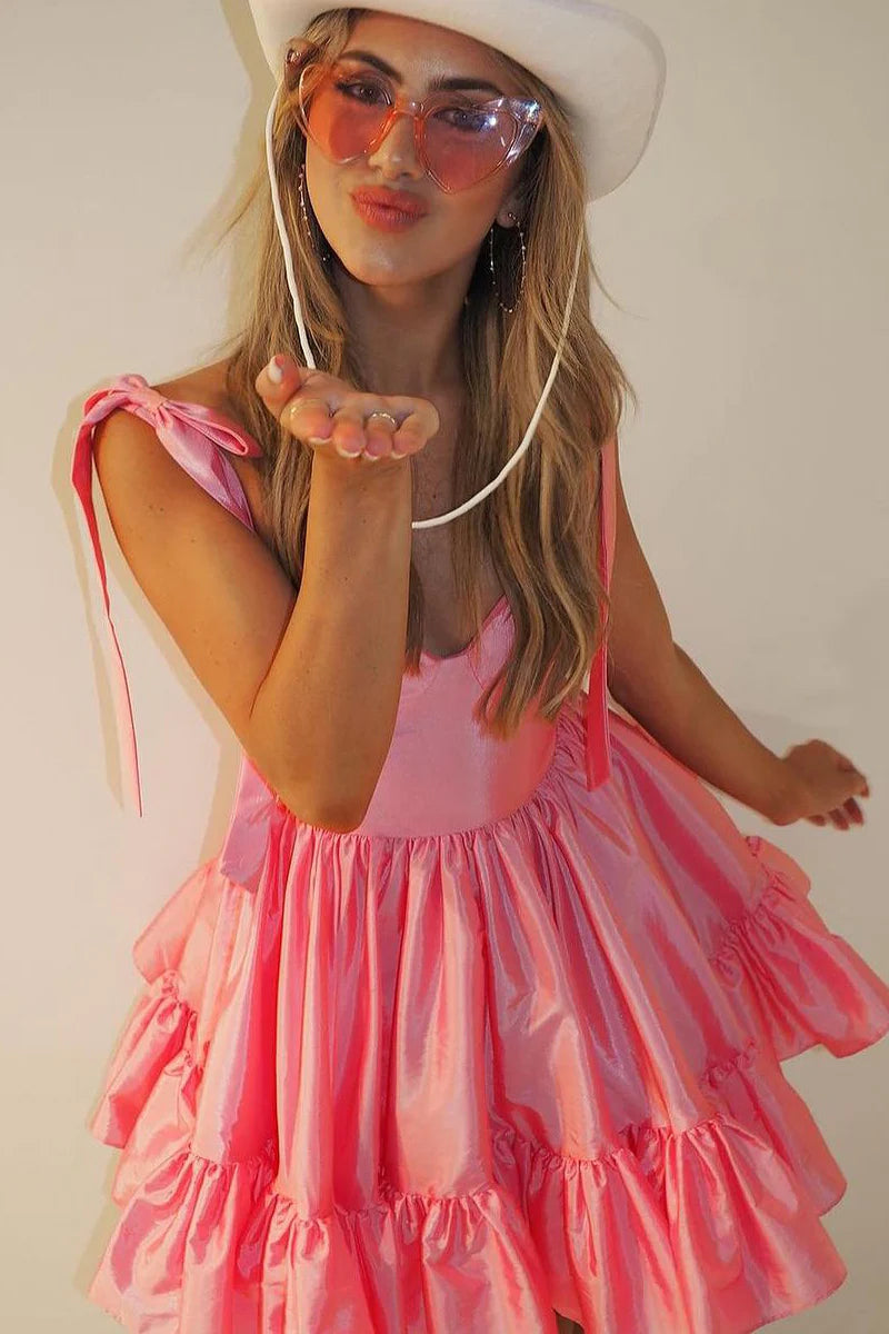 Model posing gracefully in a coral satin short homecoming dress, showing movement.