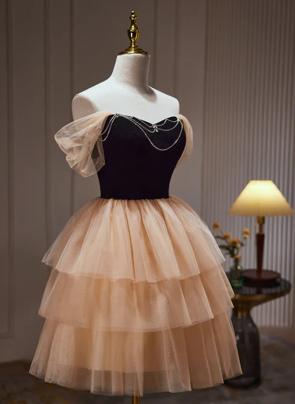 Close-up of the sweetheart neckline and bodice details of the champagne and black dress.