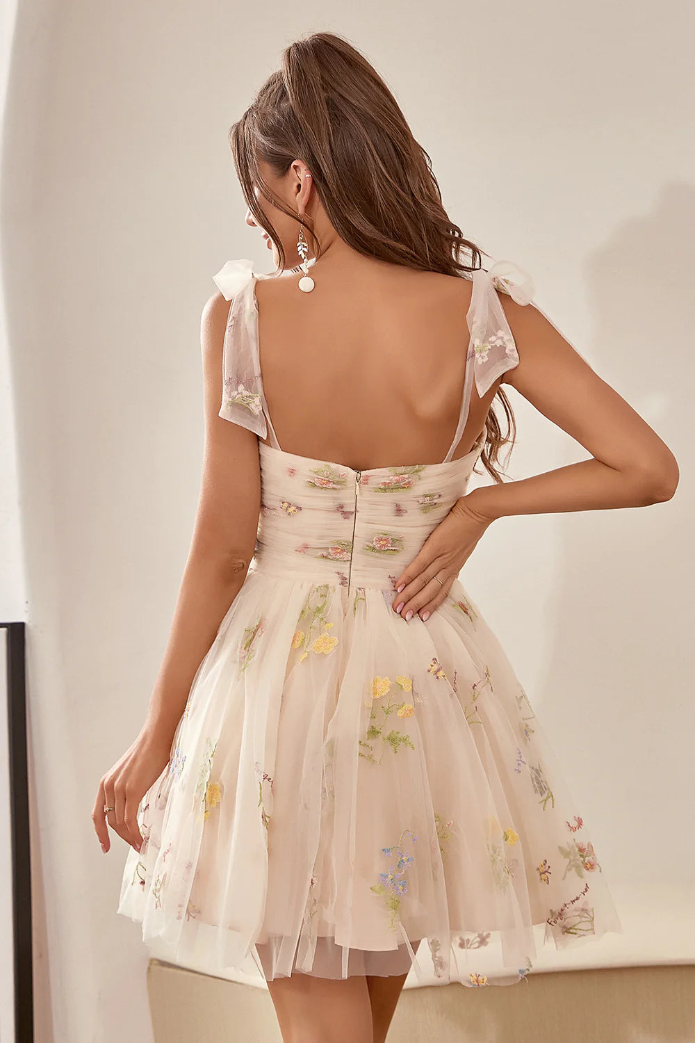 Back view of the champagne A-line dress, showcasing the delicate embroidery and flowing skirt.