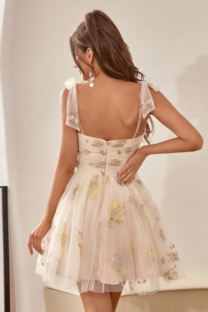 Back view of the champagne A-line dress, showcasing the delicate embroidery and flowing skirt.