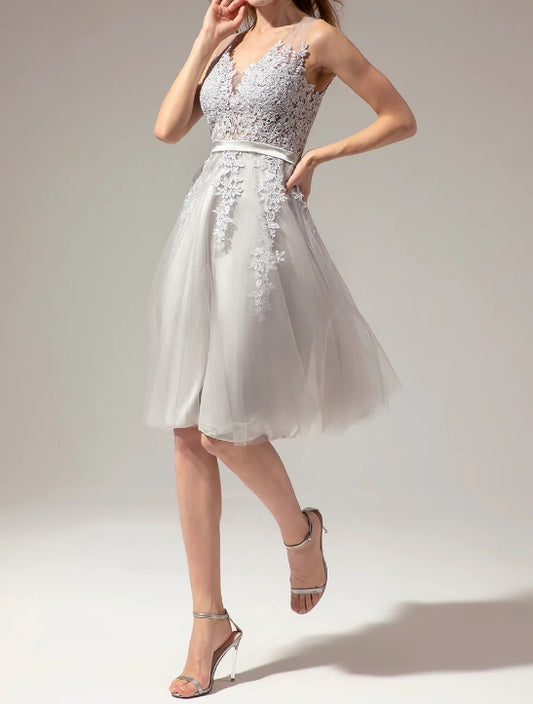 Model wearing a silver V-neck lace short homecoming dress with appliques.