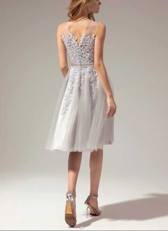 Close-up of silver lace and applique details on the V-neck dress.