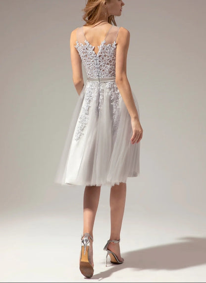 Close-up of silver lace and applique details on the V-neck dress.