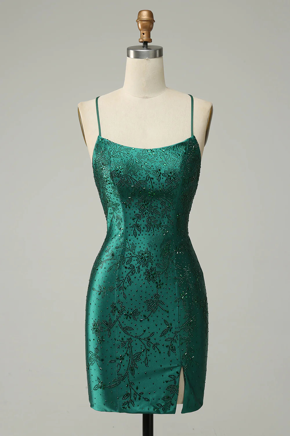 Model wearing a dark green beaded bodycon mini dress with a criss-cross back, front view.