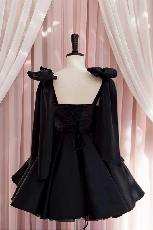 Model wearing Koutun Black Bow Tie Pleated A-line Short Dress, side view.