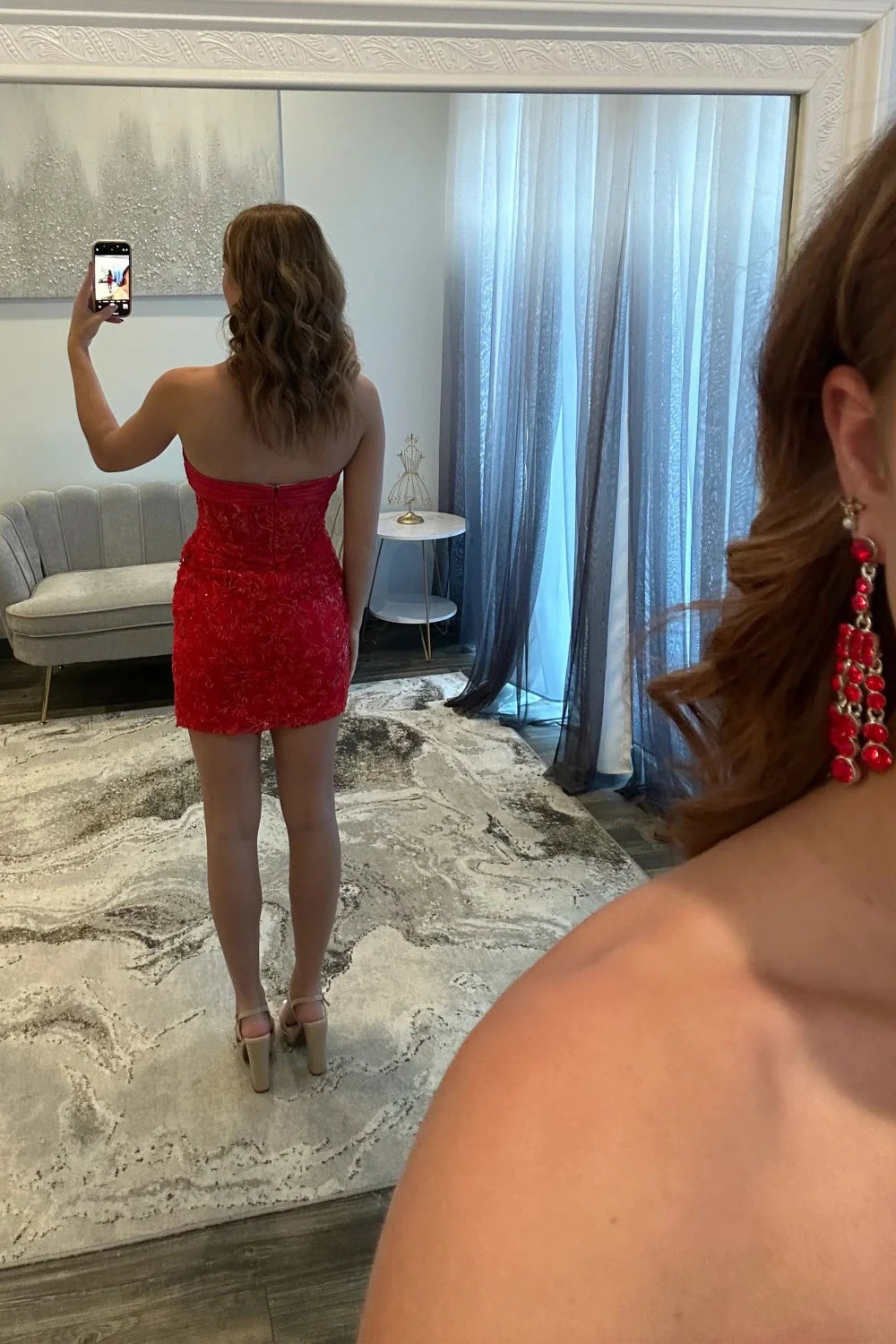 Side view of a model in a blush pink Koutun strapless dress, highlighting the floral lace skirt.