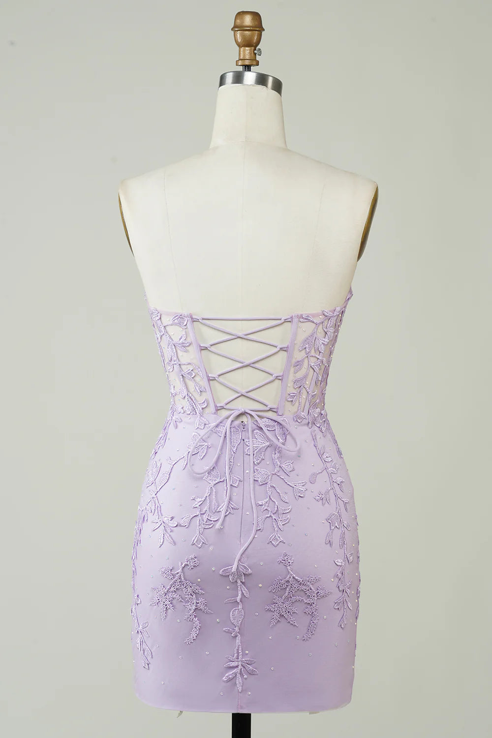 Model wearing a bodycon sweetheart corset homecoming dress with appliques.