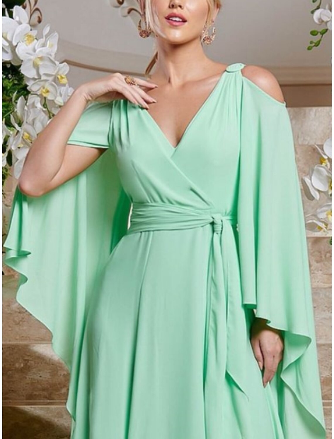 Side profile of a woman wearing a long sleeve V-neck chiffon dress, highlighting the column silhouette.