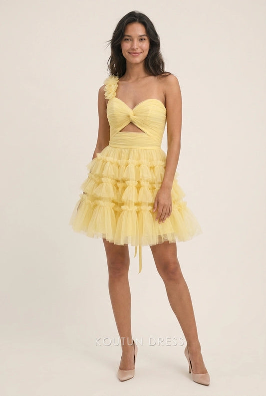 Model wearing a light yellow one-shoulder fit-and-flare homecoming dress with ruched bodice and ruffled skirt.
