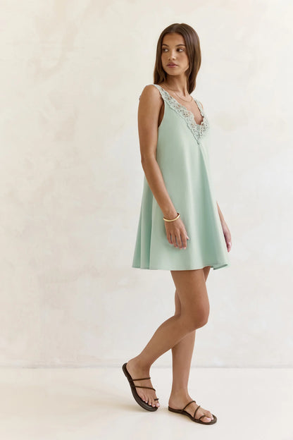 Side view of the sage green A-line mini dress, highlighting the silhouette.