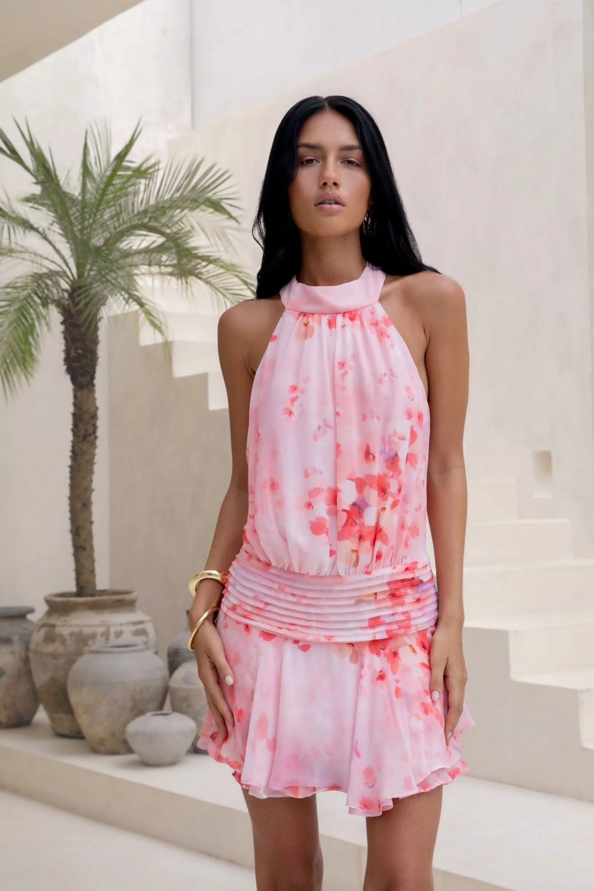 Close-up of ruched waist and ruffle hem on pink floral mini dress.